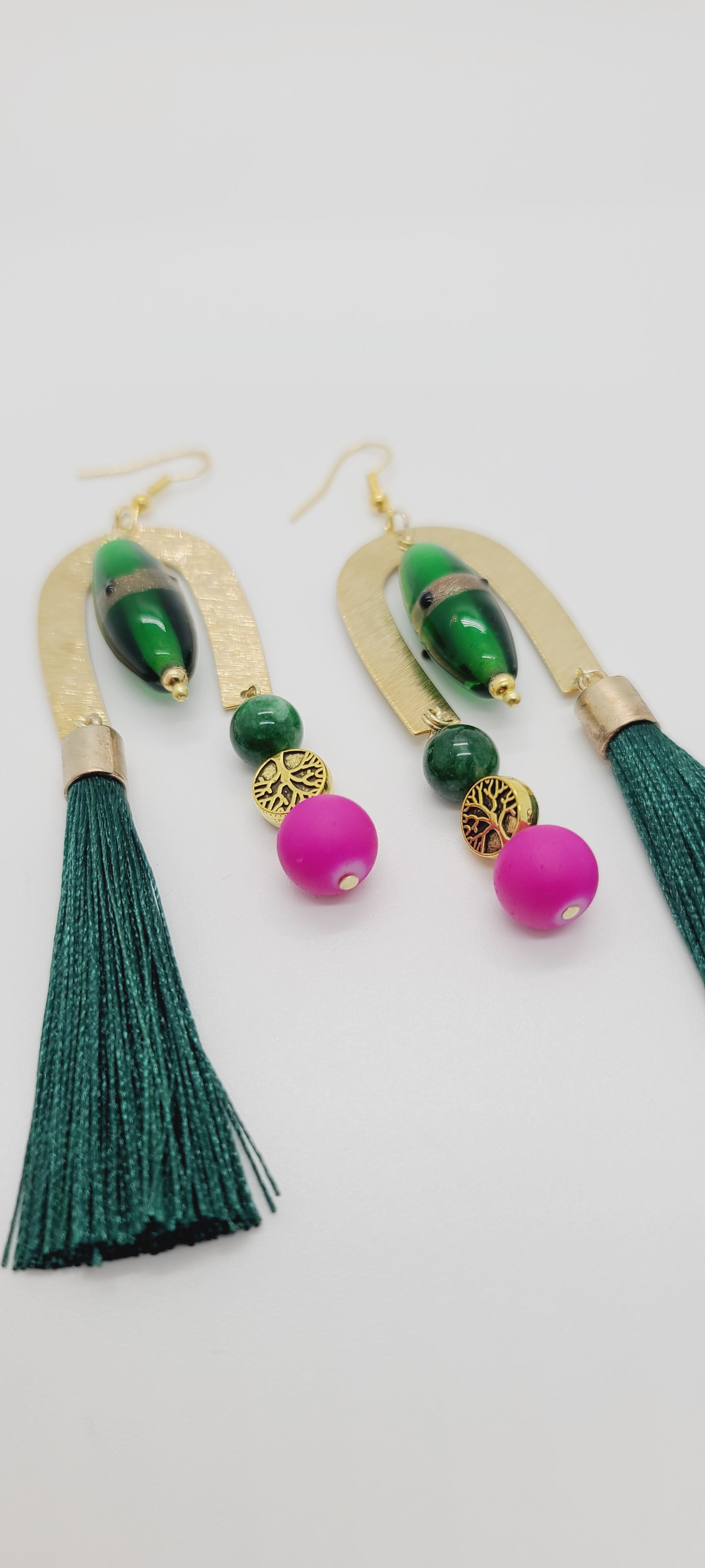 Length: 4.5 inches | Weight: 0.8 ounces  Distinctly You! These earrings are made with gold U-shape charms, green lampwork glass beads, 10mm hot pink resin beads, 8mm green Agate beads, gold tree charms, and green tassels.