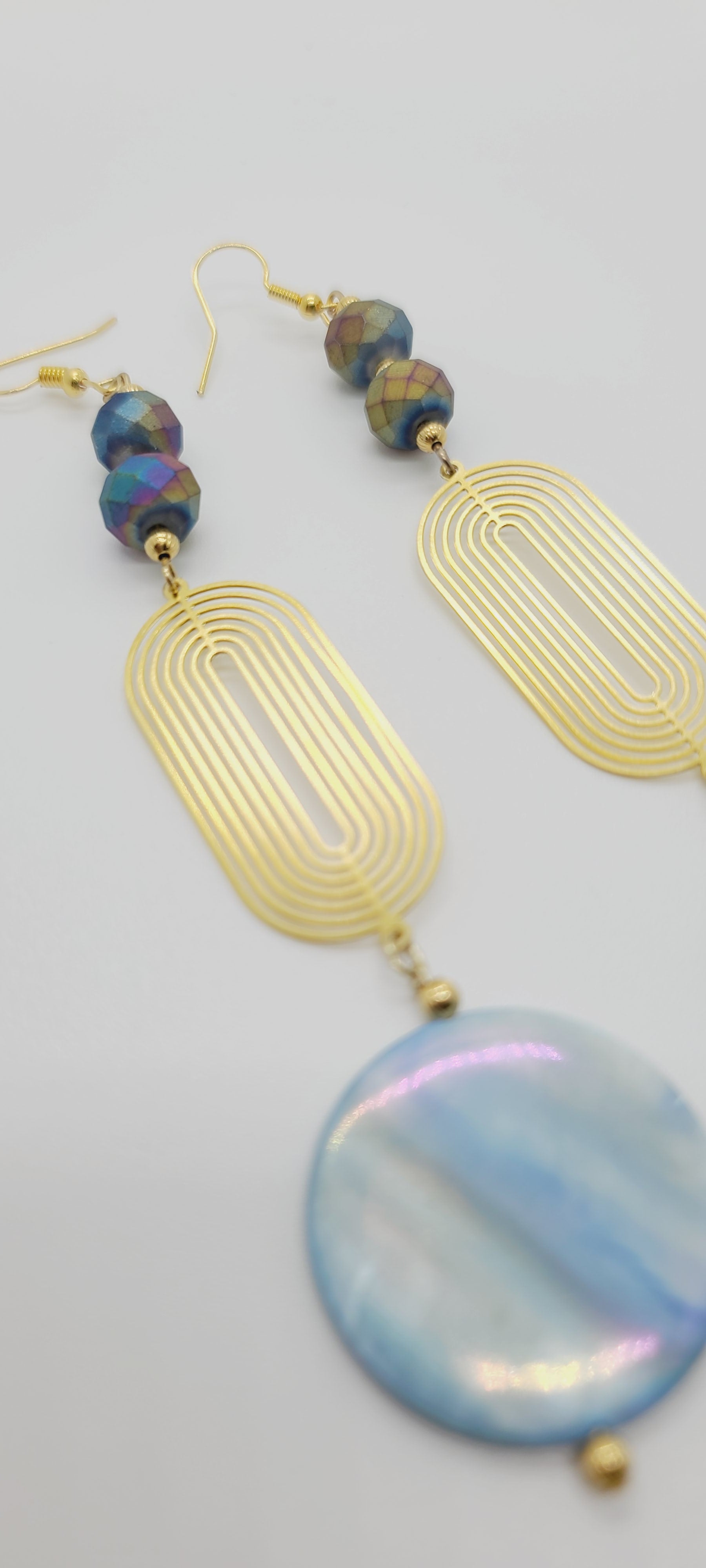 Length: 5 inches | Weight: 0.6 ounces  Distinctly You! These earrings are made with blue Abalone Shell discs, 10mm iridescent blue purple faceted glass stones, gold seed beads, and art deco oval gold charm.