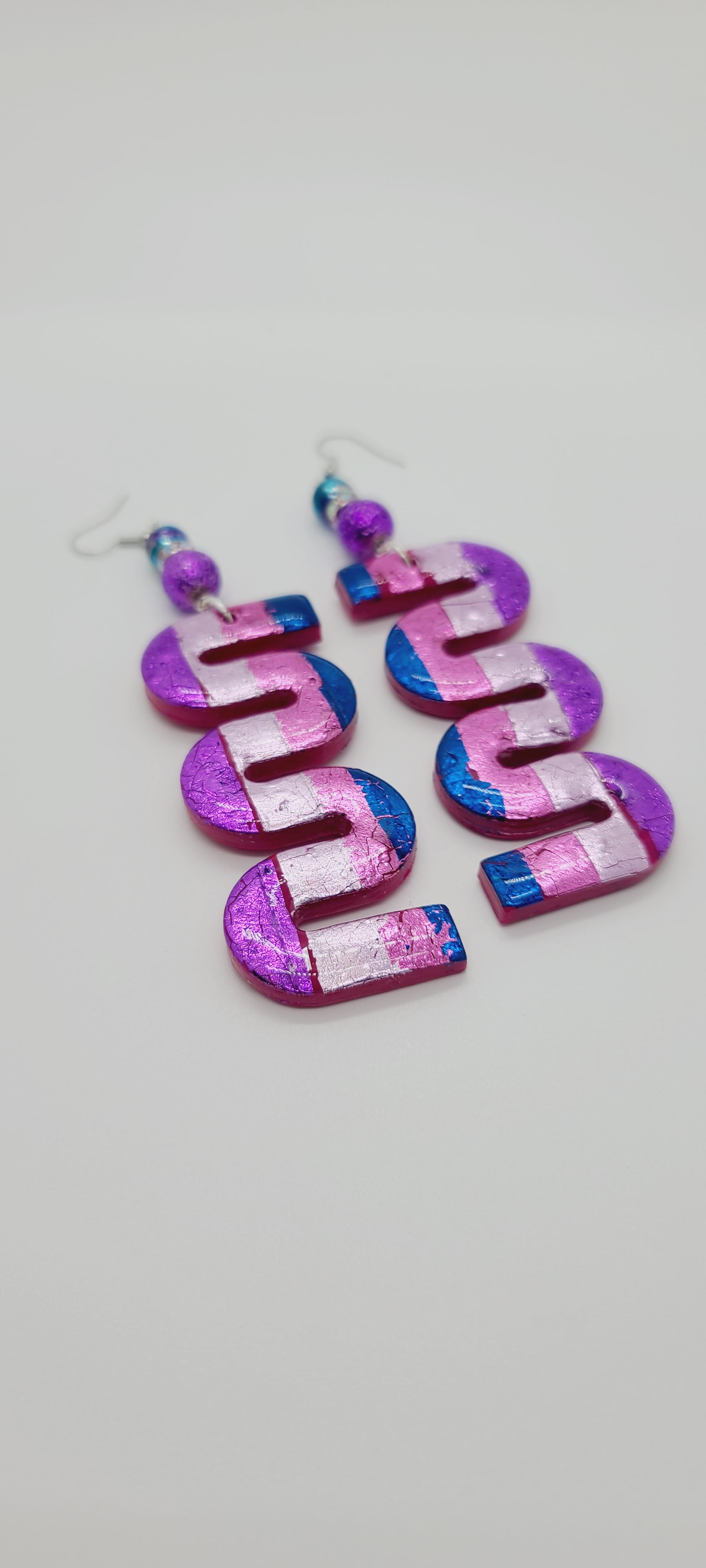Length: 4.75 inches | Weight: 1 ounce  Distinctly You! These earrings are made with swivel-shaped polymer clay in blue pink purple lilac, 10mm purple lava beads, 8mm multi-colored glass beads, and rhinestone rondelles.