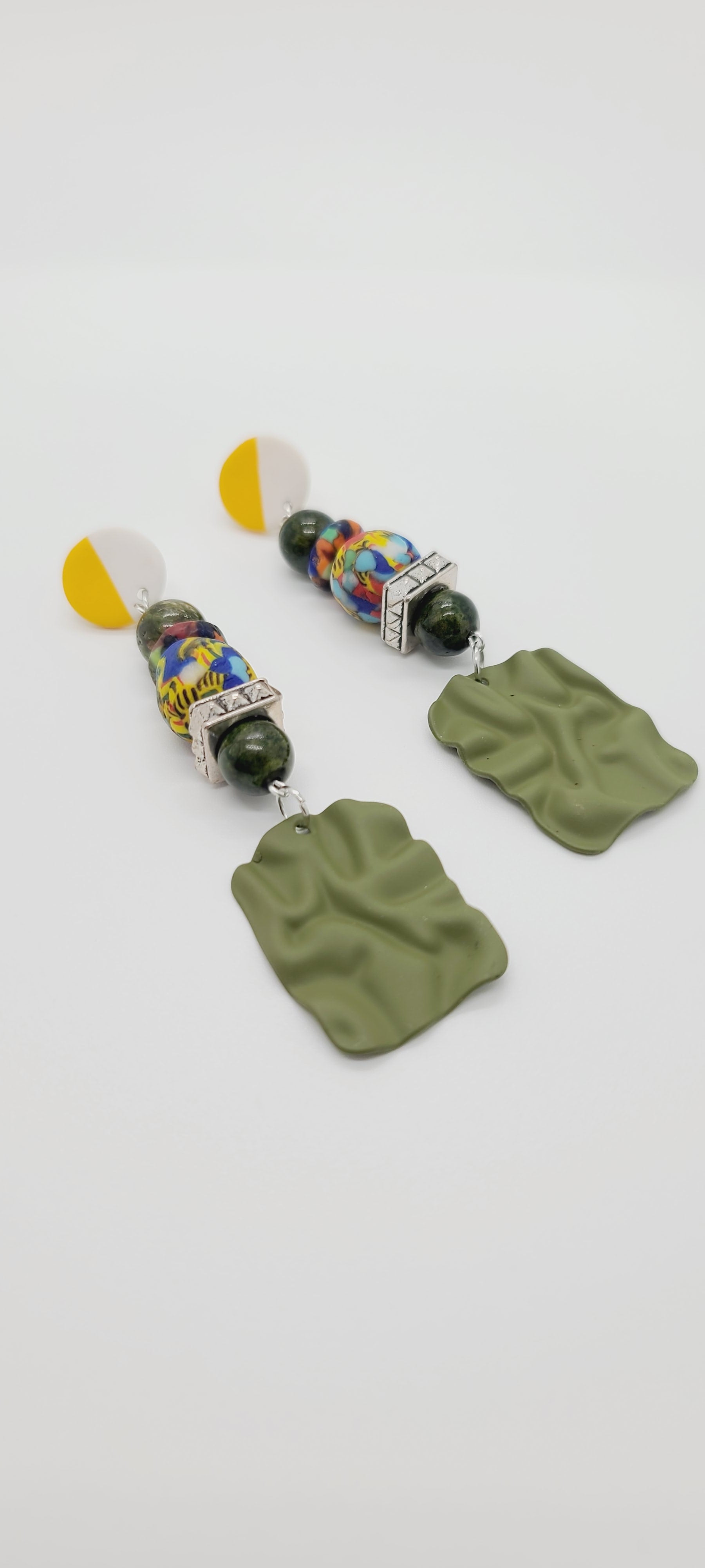 Length: 3.5 inches | Weight: 1.1 ounces  Distinctly You! These yellow and white ceramic post earrings are made with olive green rubbered metal charms, 10mm olive green Agate atones, 14mm house medley Ghana glass beads and rondelles, and silver squared rondelles.
