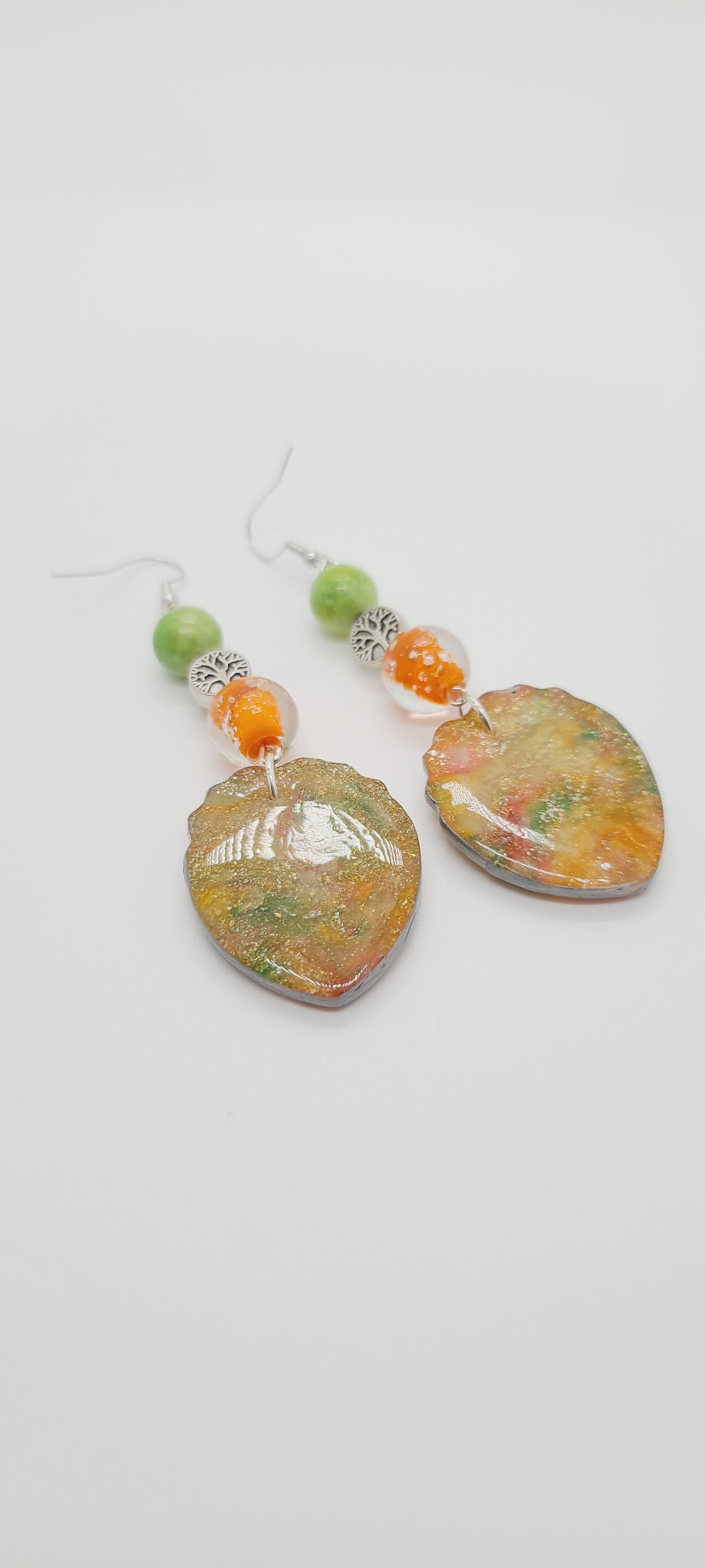 Length: 3.5 inches | Weight: 0.7 ounces  Distinctly You! These earrings are made with teardrop-shaped polymer clay in orange green gold with gold flakes, 12mm clear and orange glass beads, 10mm matte green ceramic beads, and silver tree charm.