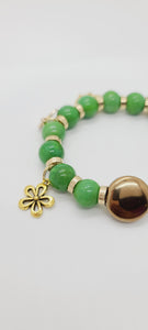 Length: 7.75 inches | Weight: 2 ounces  Distinctly You! This bracelet is made with 12mm rich green ceramic Beads, 16mm gold glass disc centerpiece, with gold charms and spacers.