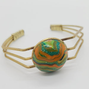 Length: 6.75 inches | Weight: 0.6 ounces  Distinctly You! This brass metal bracelet is made with multi-colored green, orange, gold swirl polymer clay stone covered in resin.