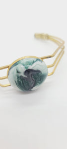 Length: 6.75 inches | Weight: 0.6 ounces  Distinctly You! This brass metal bracelet is made with multi-colored green, white, black swirl polymer clay covered in resin.