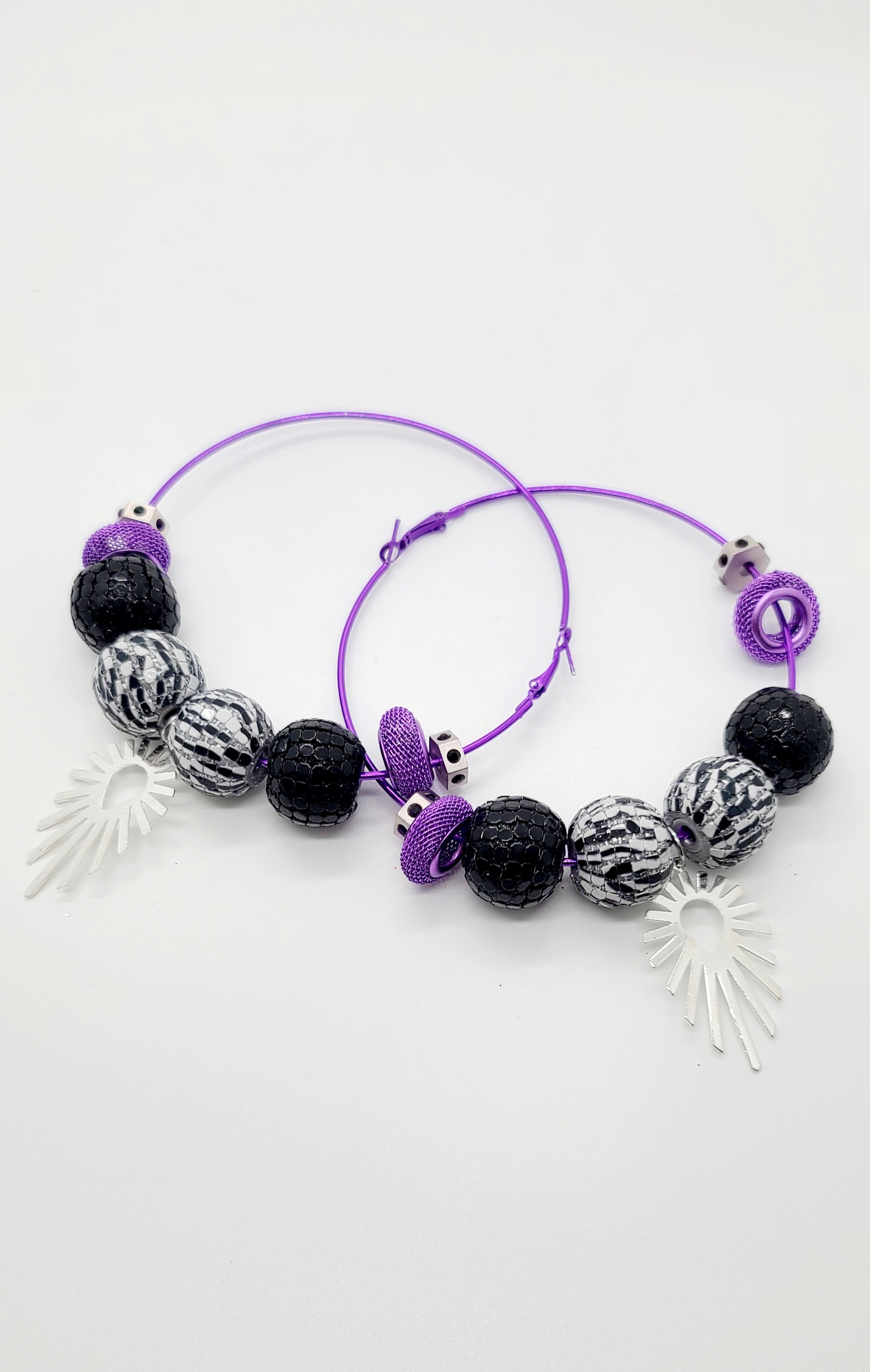 Length: 3.5x3.5 inches | Weight: 2.2 ounces  Distinctly You! These earrings are made with large purple hoops,15mm black and white striped beads, black and silver sequin beads, purple mesh rondelles, chrome hexagon rondelles, and silver sunburst charm.