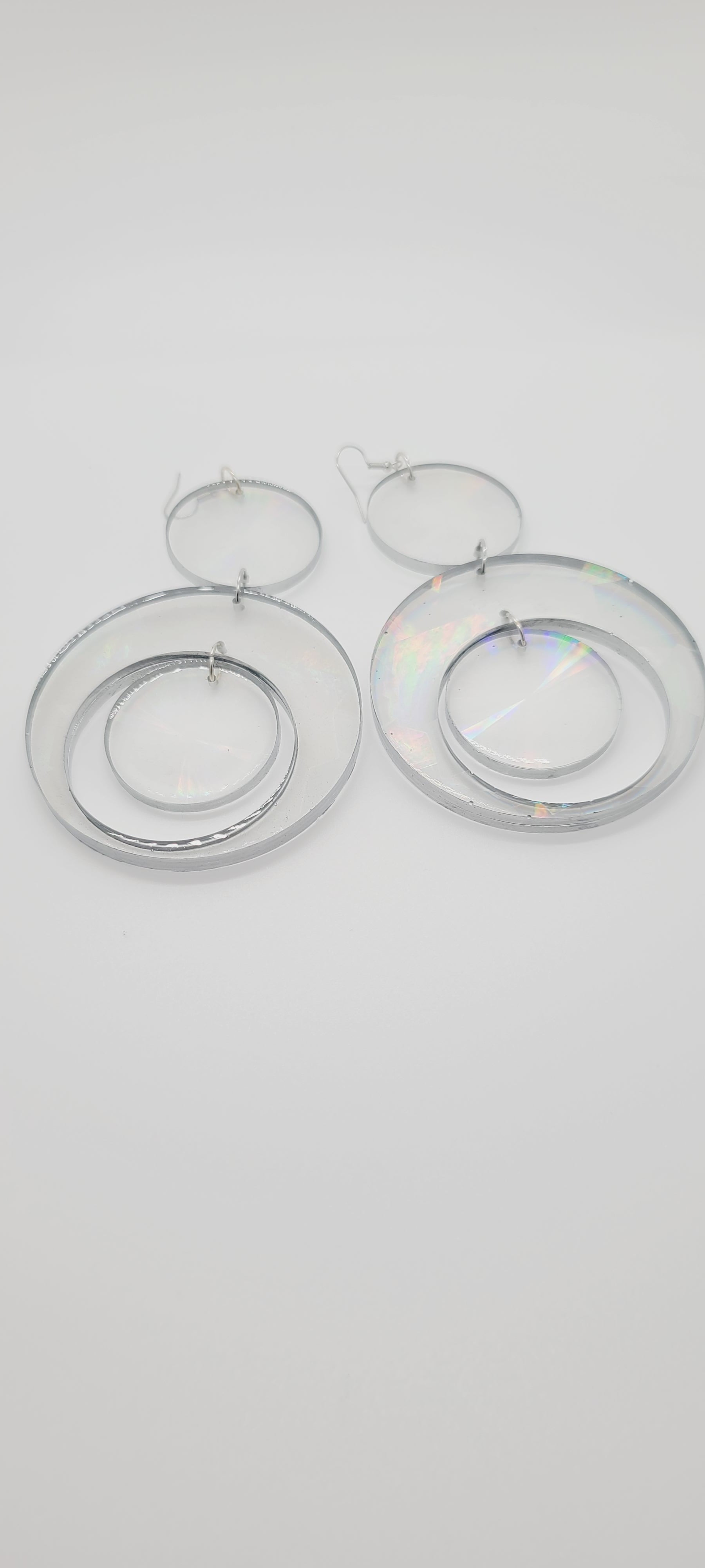 Length: 5.5 inches | Weight: 1.8 ounces  Distinctly You! These earrings are made with clear resin hologram hoops with silver edge. 