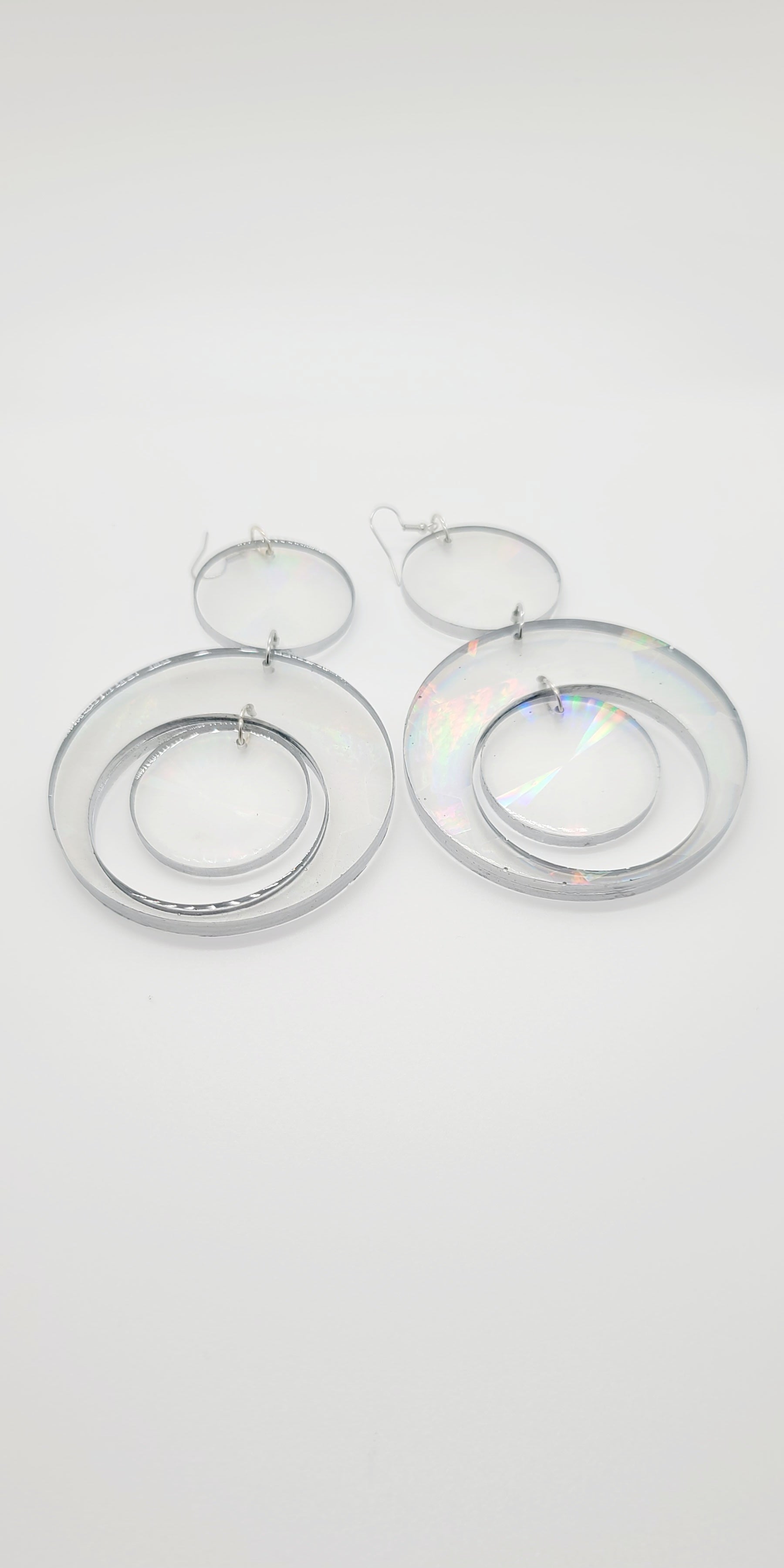 Length: 5.5 inches | Weight: 1.8 ounces  Distinctly You! These earrings are made with clear resin hologram hoops with silver edge. 