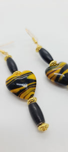 Length: 3 inches | Weight: 0.6 ounces  Distinctly You! These earrings are made with black and gold swirl glass heart shape stones, black hair bone, accented with gold rondelles.