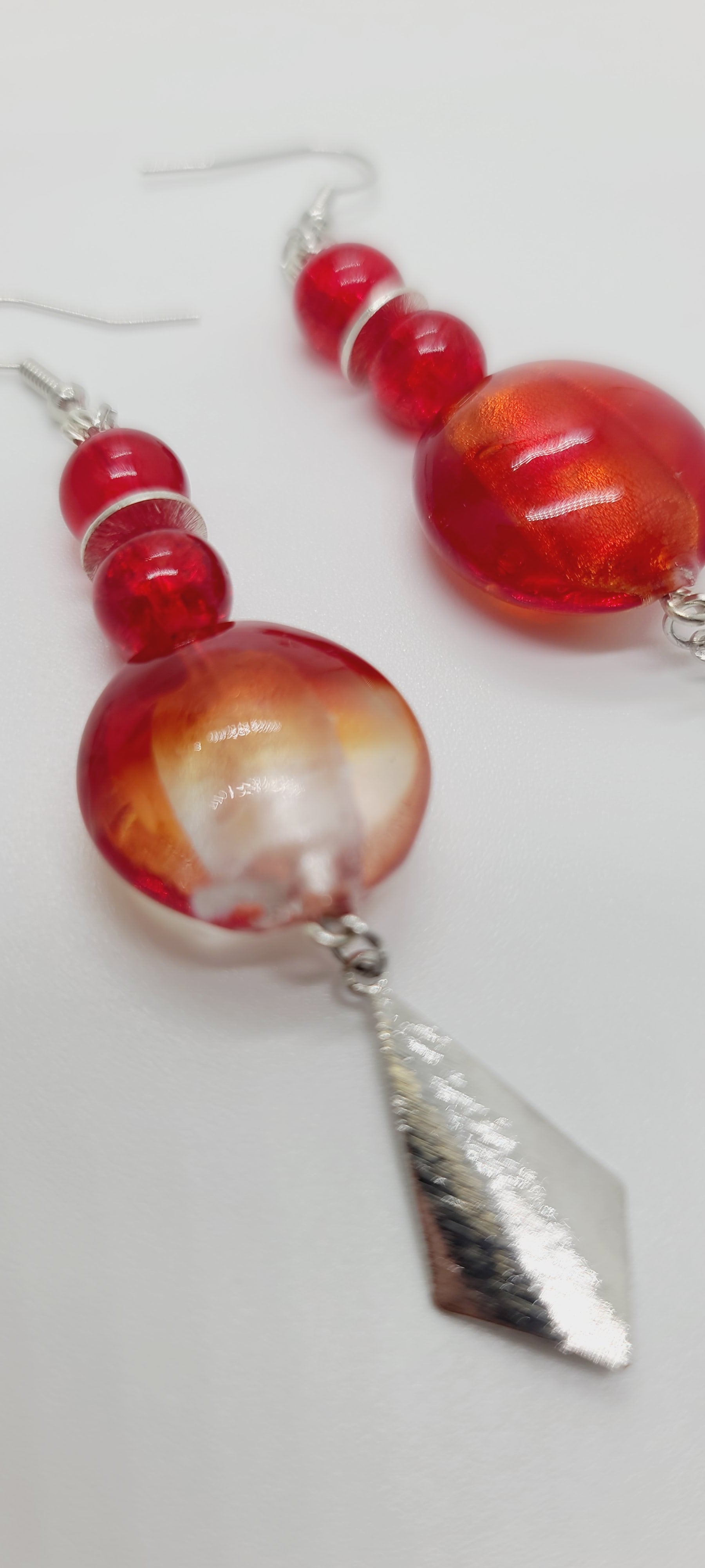Length: 3 inches | Weight: 0.6 ounces  Distinctly You! These earrings are made with red and silver swirl Italian Murano glass stones, 8mm red glass beads, accented with silver rondelles and charms.