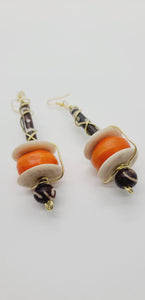 Length: 4 inches | Weight: 1.3 ounces  Distinctly You! These earrings are made with large orange colored bone beads, white Batik bone discs, black and white hair bone, Batik bone beads, and gold wire wrapping.