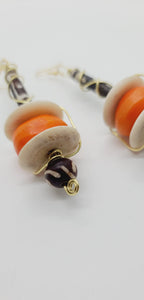 Length: 4 inches | Weight: 1.3 ounces  Distinctly You! These earrings are made with large orange colored bone beads, white Batik bone discs, black and white hair bone, Batik bone beads, and gold wire wrapping.