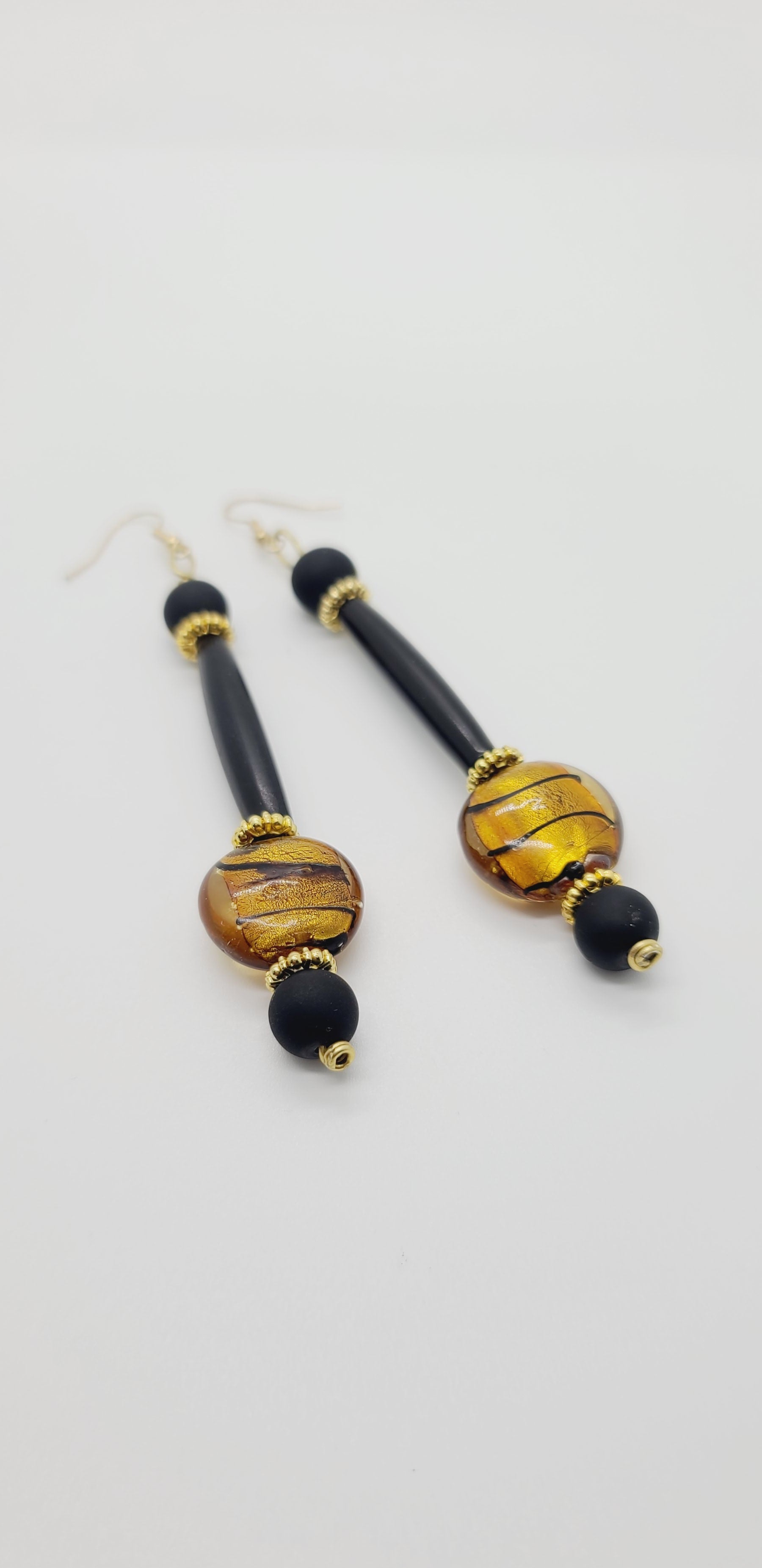 Length: 4.5 inches | Weight: 0.8 ounces  Distinctly You! These earrings are made with gold and black Italian Murano glass stones,10mm matte black glass beads, black hair bone tube, and gold rondelles.