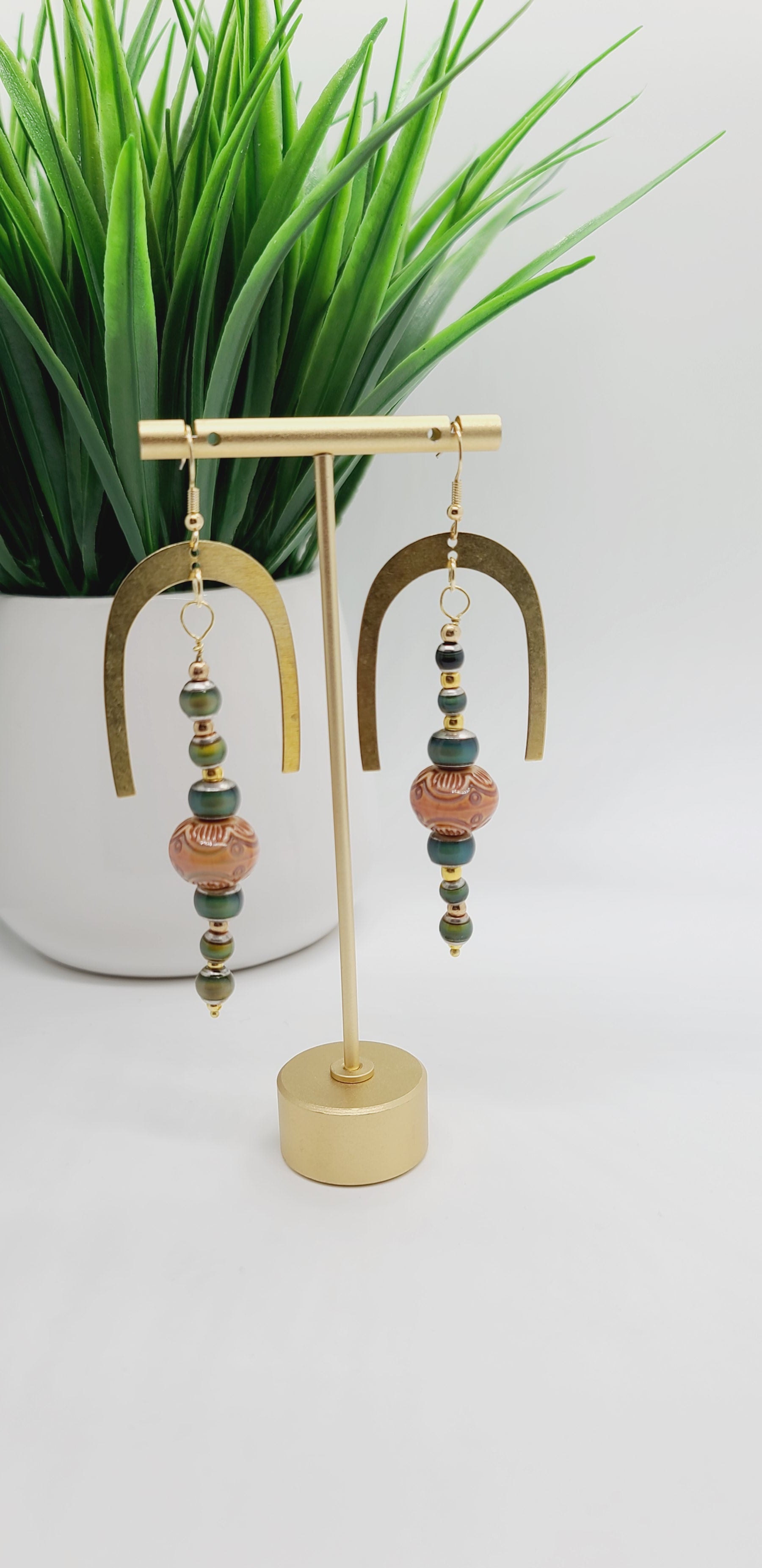 Length: 4 inches | Weight: 0.8 ounces  Distinctly You! These earrings are made with gold horseshoe charm, amber printed wood covered with resin beads, 6mm and 4mm green resin beads, and gold seed beads.