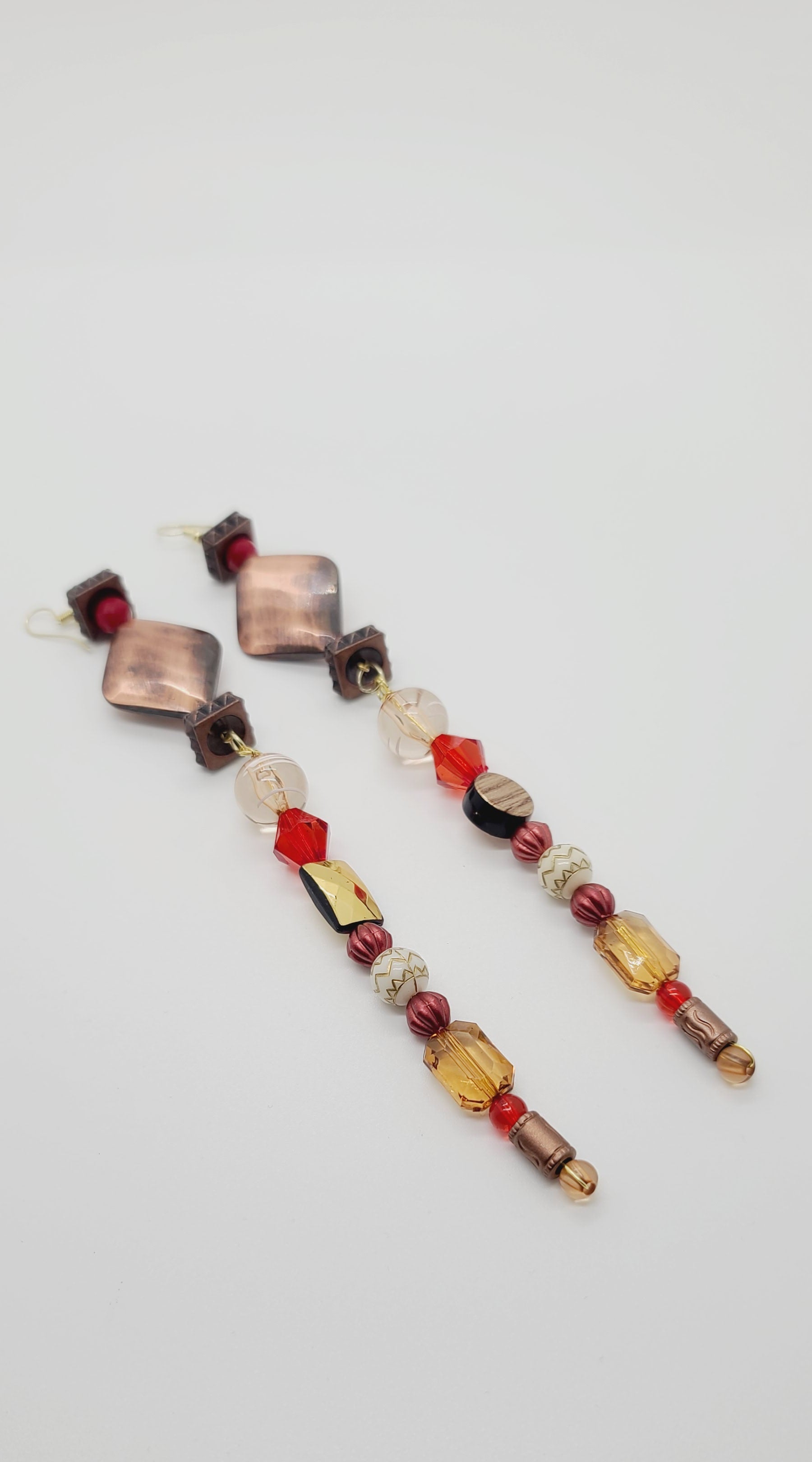 Length: 7 inches | Weight: 1.1 ounces  Distinctly You! These earrings are made with diamond-shaped copper charm, copper square rondelles, 6mm red glass faceted beads,10mm red faceted resin beads, 12mm clear and white glass beads, 10mm clear gold emerald cut beads, 6mm copper beads, 8mm gold carved white beads, copper spacers, 4mm red and tan beads.