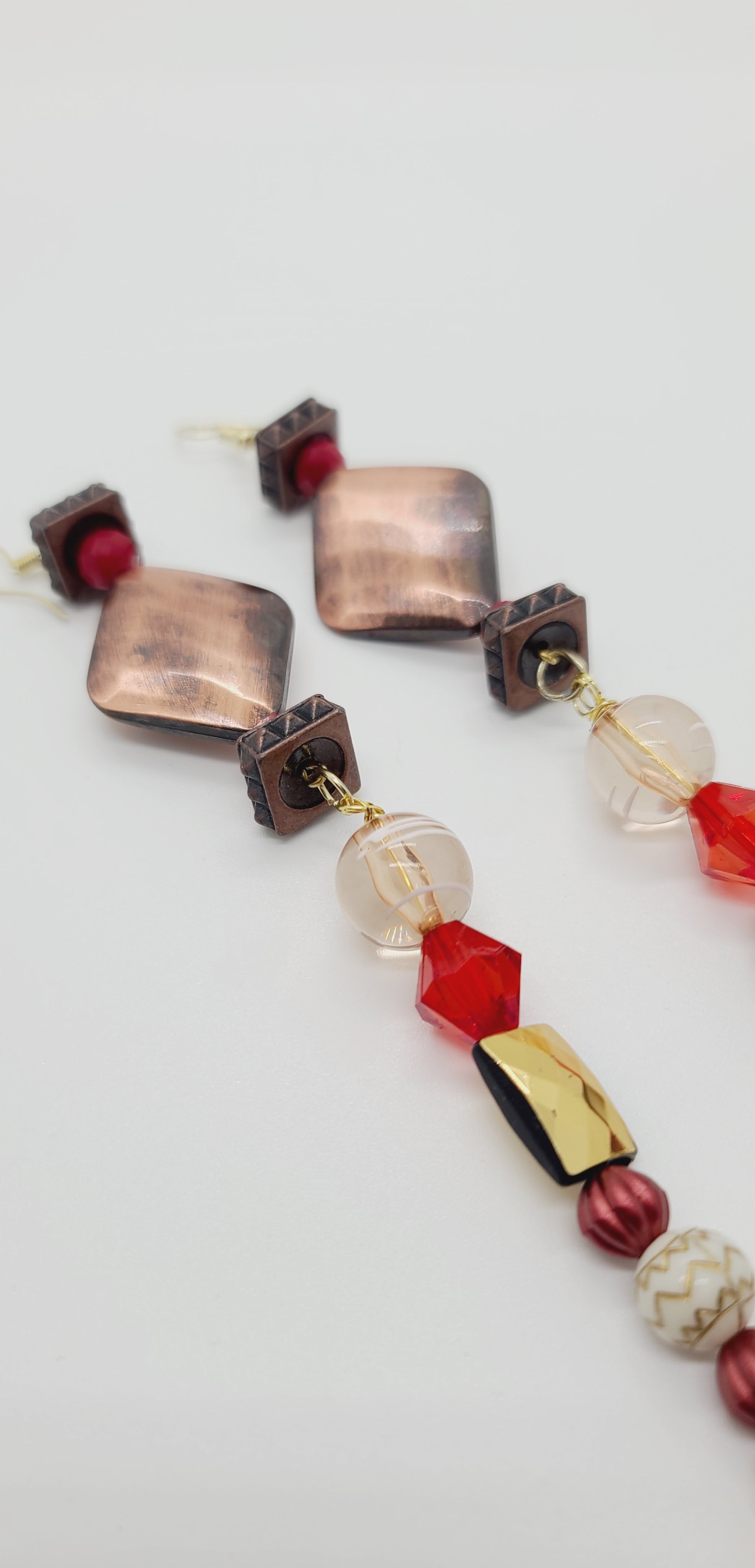 Length: 7 inches | Weight: 1.1 ounces  Distinctly You! These earrings are made with diamond-shaped copper charm, copper square rondelles, 6mm red glass faceted beads,10mm red faceted resin beads, 12mm clear and white glass beads, 10mm clear gold emerald cut beads, 6mm copper beads, 8mm gold carved white beads, copper spacers, 4mm red and tan beads.