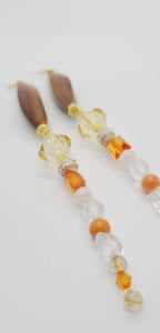 Length: 7 inches | Weight: 0.9 ounces  Distinctly You! These earrings are made with elongated wooden Bicone beads, gold spacers, 14mm pale gold beads, 10mm and 4mm orange faceted resin beads, 8mm white gold carved resin covered beads, 8mm clear faceted resin beads, and 3mm clear resin beads.