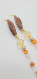 Length: 7 inches | Weight: 0.9 ounces  Distinctly You! These earrings are made with elongated wooden Bicone beads, gold spacers, 14mm pale gold beads, 10mm and 4mm orange faceted resin beads, 8mm white gold carved resin covered beads, 8mm clear faceted resin beads, and 3mm clear resin beads.