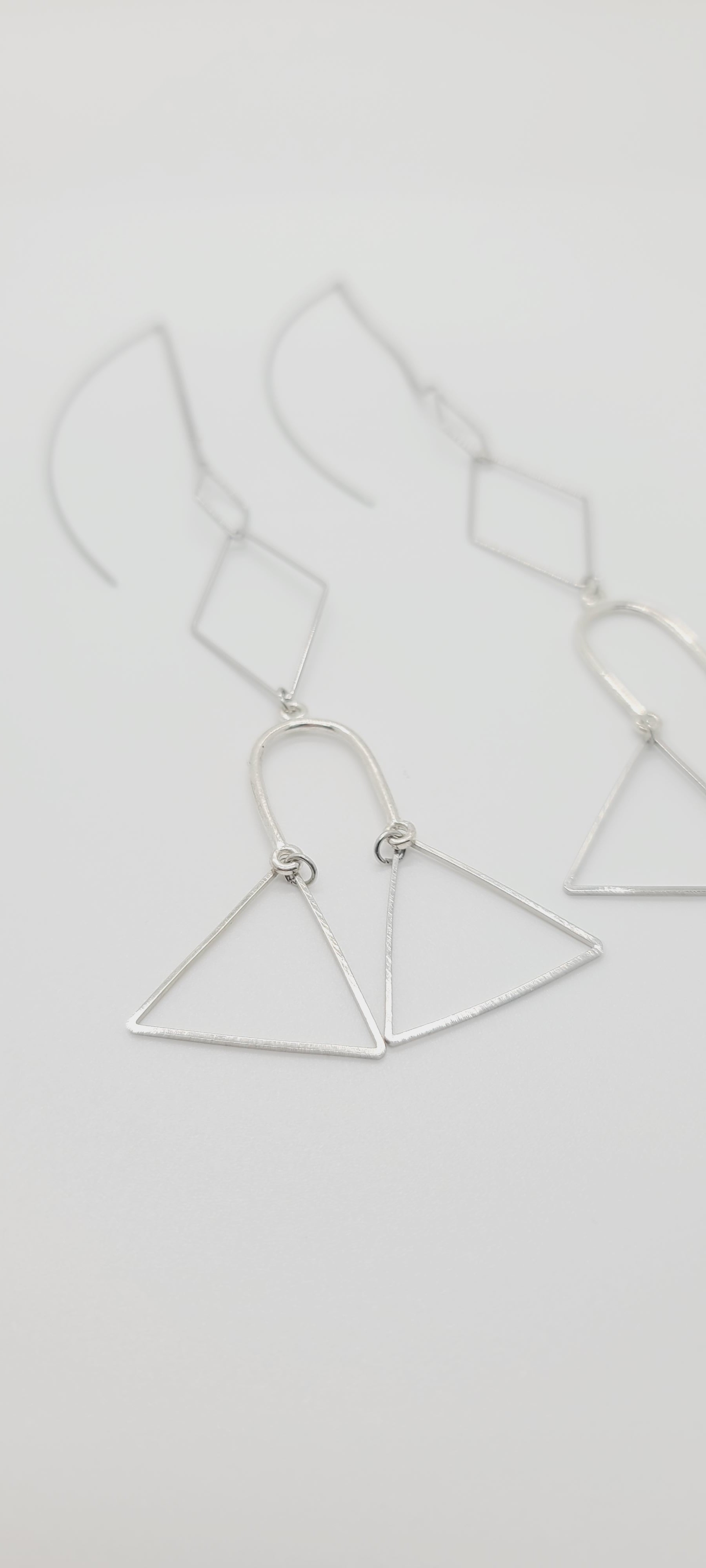 Length: 6 inches | Weight: 0.2 ounces  Distinctly You! These silver wire hook earrings are made with silver chains, silver charms in shapes of diamonds, triangles, and horseshoes.