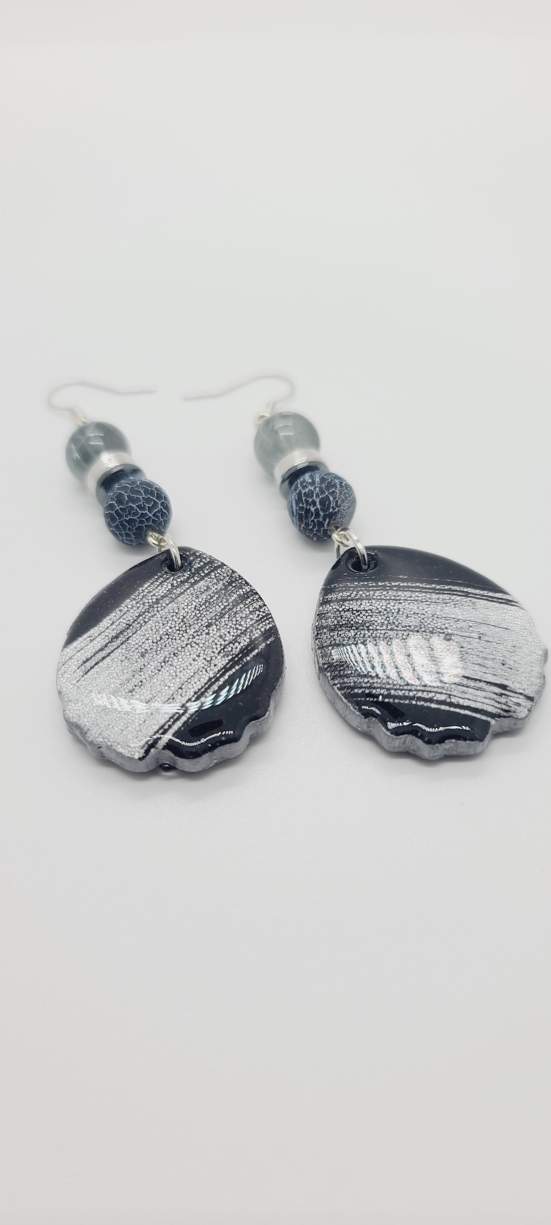 Length: 3.5 inches | Weight: 0.7 ounces  Distinctly You! These earrings are made with black and silver brushed teardrop-shaped polymer clay, 10mm black and white crackle glass beads, 10mm grey clear glass, silver and  Hematite rondelles.
