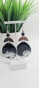 Length: 4 inches | Weight: 1.2 ounces  Distinctly You! These earrings are made with black and silver embossed polymer clay, silver hammered curved charms, and 10mm black Onyx beads, and silver filigree beads.