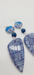 Length: 5 inches | Weight: 1 ounce  Distinctly You! These earrings are made with sapphire blue teardrop shaped polymer clay, blue foil, ethic hand painted white Kente print beads, 10mm blue matte Druzy beads, and blue and white striped seed beads.