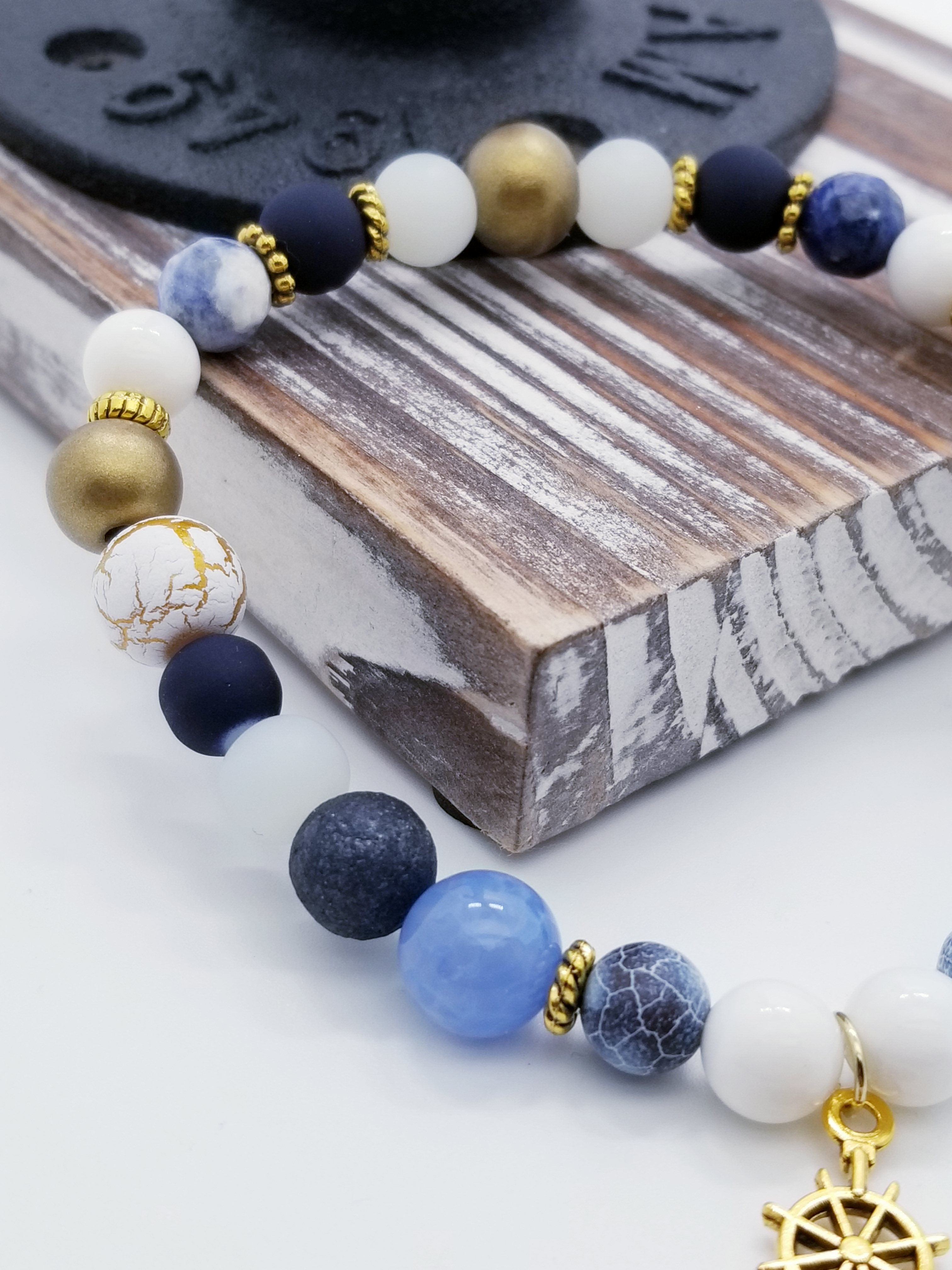 Honor, Courage, and Commitment (US Navy core values) inspired bracelet to honor our troops, veterans, and the families that support them! Anchor charm with white turquoise beads, indigo and navy marbled beads, gold and white marbled beads, navy matte glass beads, sky blue glass beads, gold faceted spacer beads, and gold spacers. 