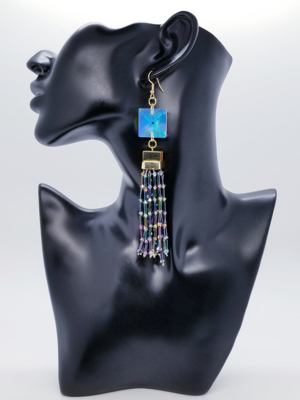 PLEASE BE AWARE: Earrings Hang Past Shoulders   Length: 5.5 inches | Weight: 1.4 ounces  Distinctly You! The earrings are handmade using iridescent square crystal stone beads, iridescent glass tassels, and hypoallergenic hooks with back closures. 