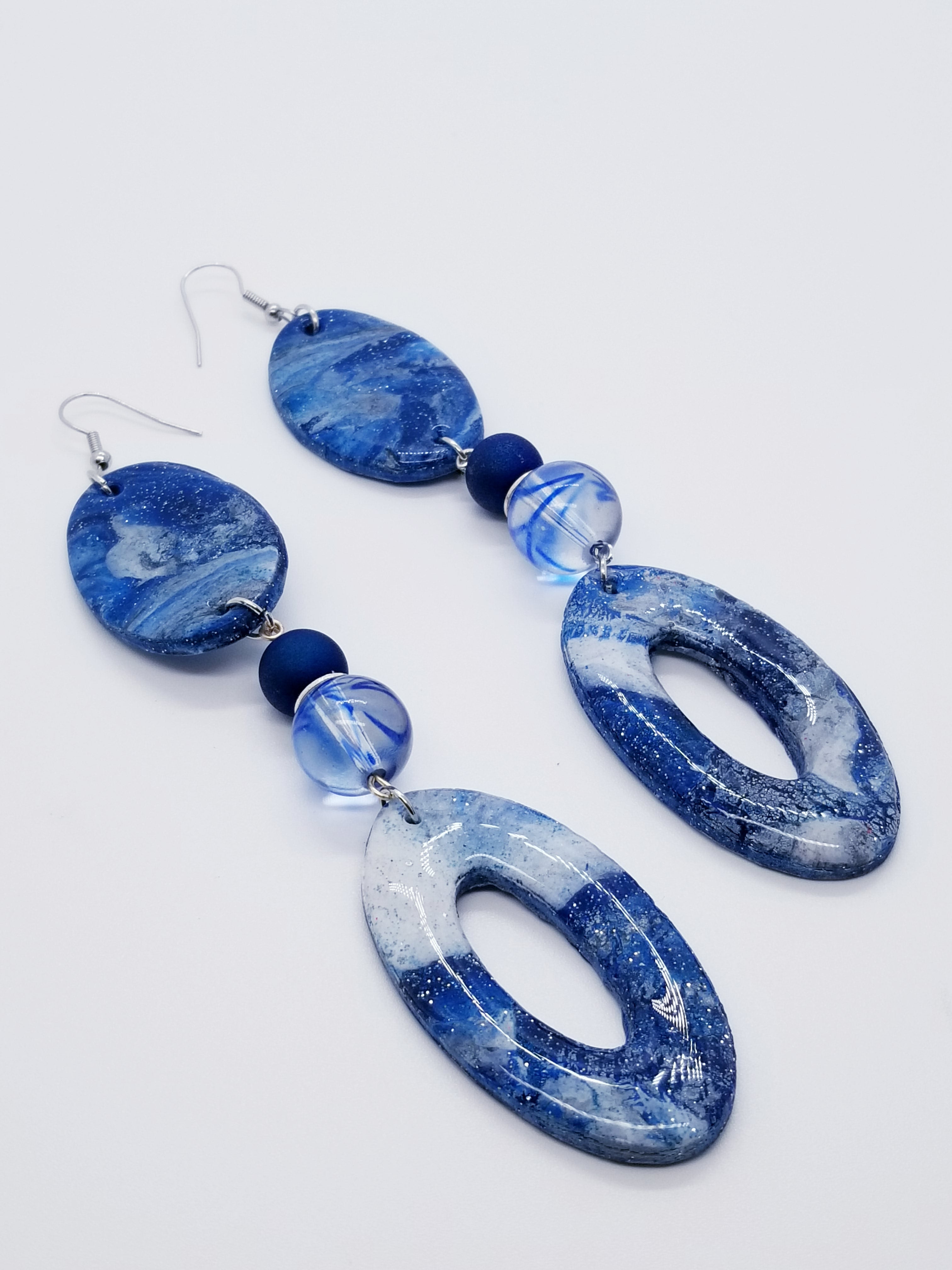 PLEASE BE AWARE: Earrings Hang Past Shoulders   Length: 5.5 inches | Weight: 1 ounce  Distinctly You! The earrings are handmade using blue and silver swirl polymer clay design with resin overlay, 12mm blue swirl glass beads, 10mm blue Druzy Agate beads, silver rondelle spacers, silver head pins, and hypoallergenic hooks with back closures. 