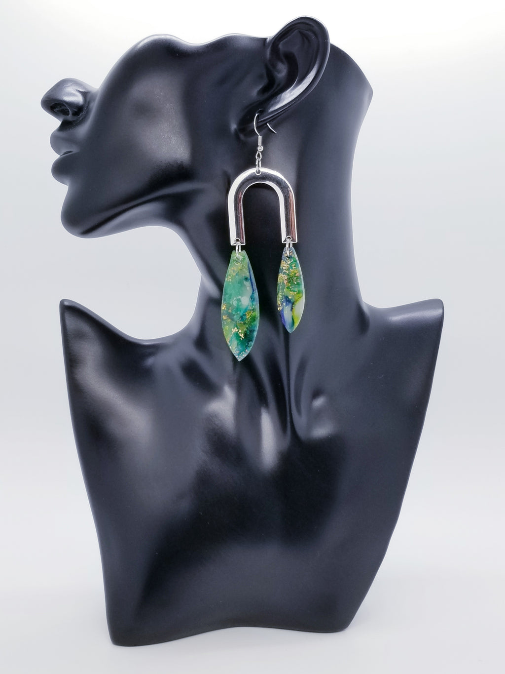 Length: 4 inches | Weight: 0.7 ounces  Distinctly You! The earrings are handmade using green and gold swirl resin design, silver u-shaped charms, and hypoallergenic hooks with back closures. 