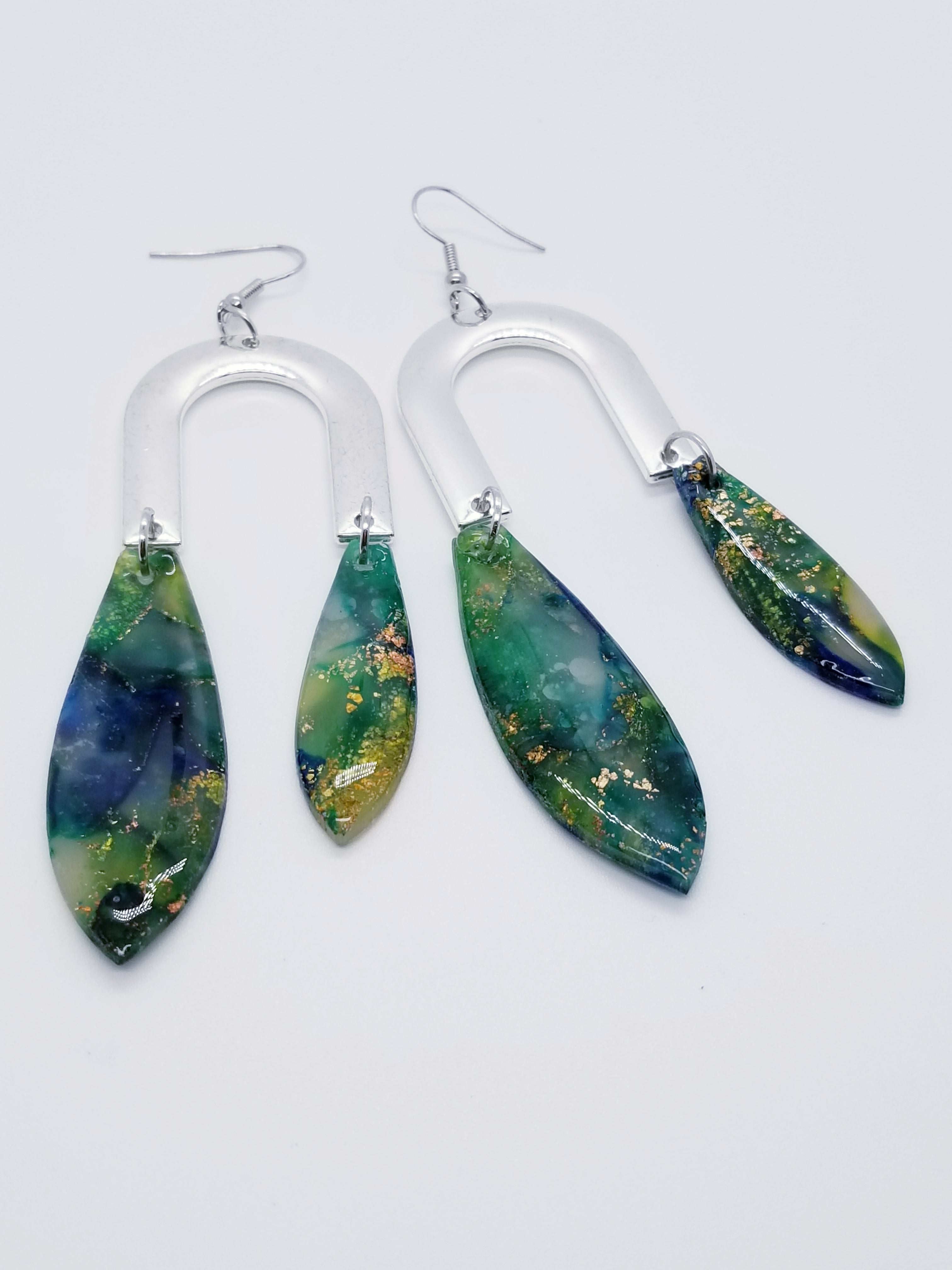 Length: 4 inches | Weight: 0.7 ounces  Distinctly You! The earrings are handmade using green and gold swirl resin design, silver u-shaped charms, and hypoallergenic hooks with back closures. 