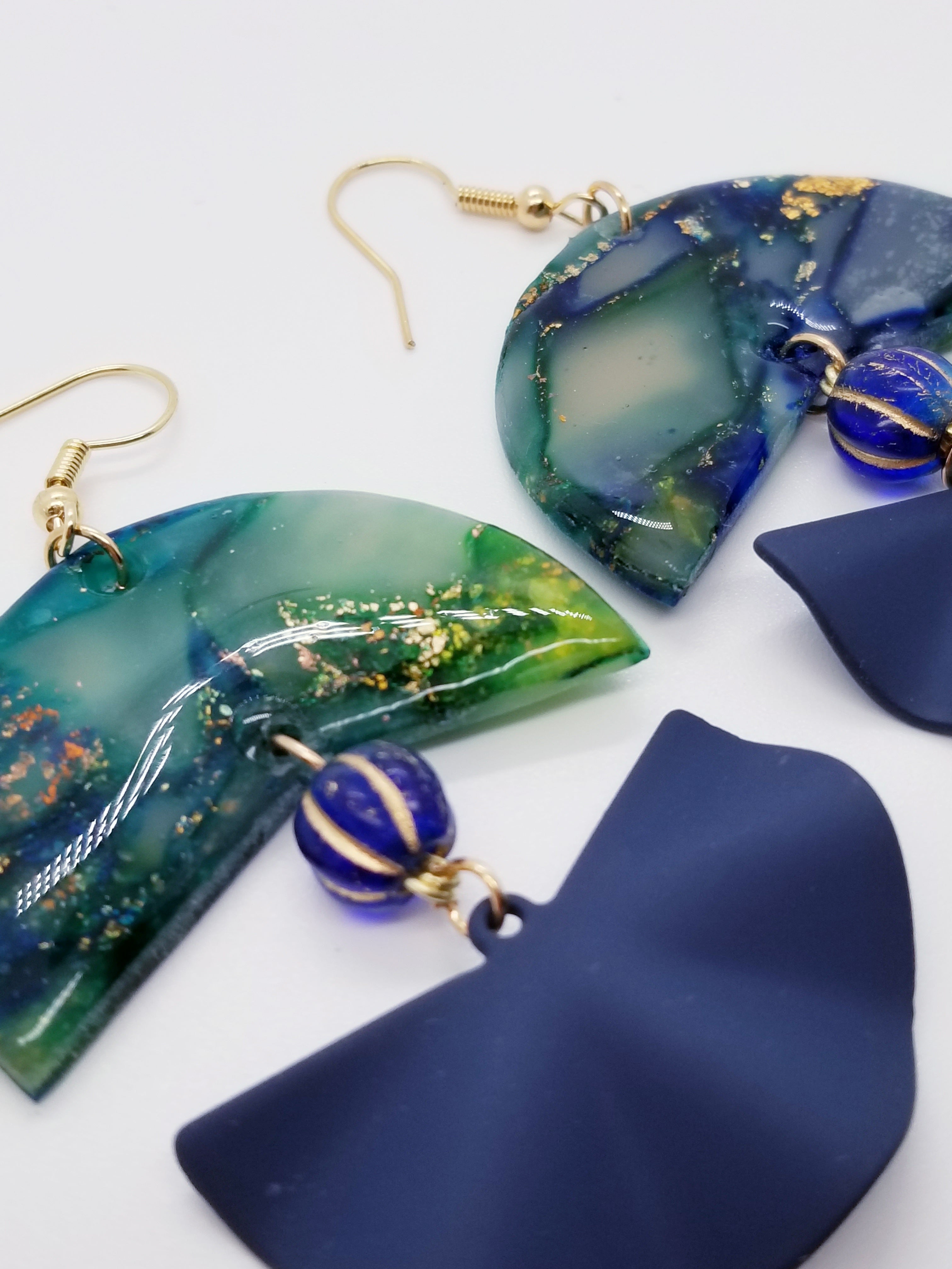 Length: 3 inches | Weight: 0.7 ounces  Designed just for you! The earrings are handmade using green blue and swirl gold resin design, matte blue fanned covered charm, 8mm blue Czech melon beads, and hypoallergenic hooks with back closures. 