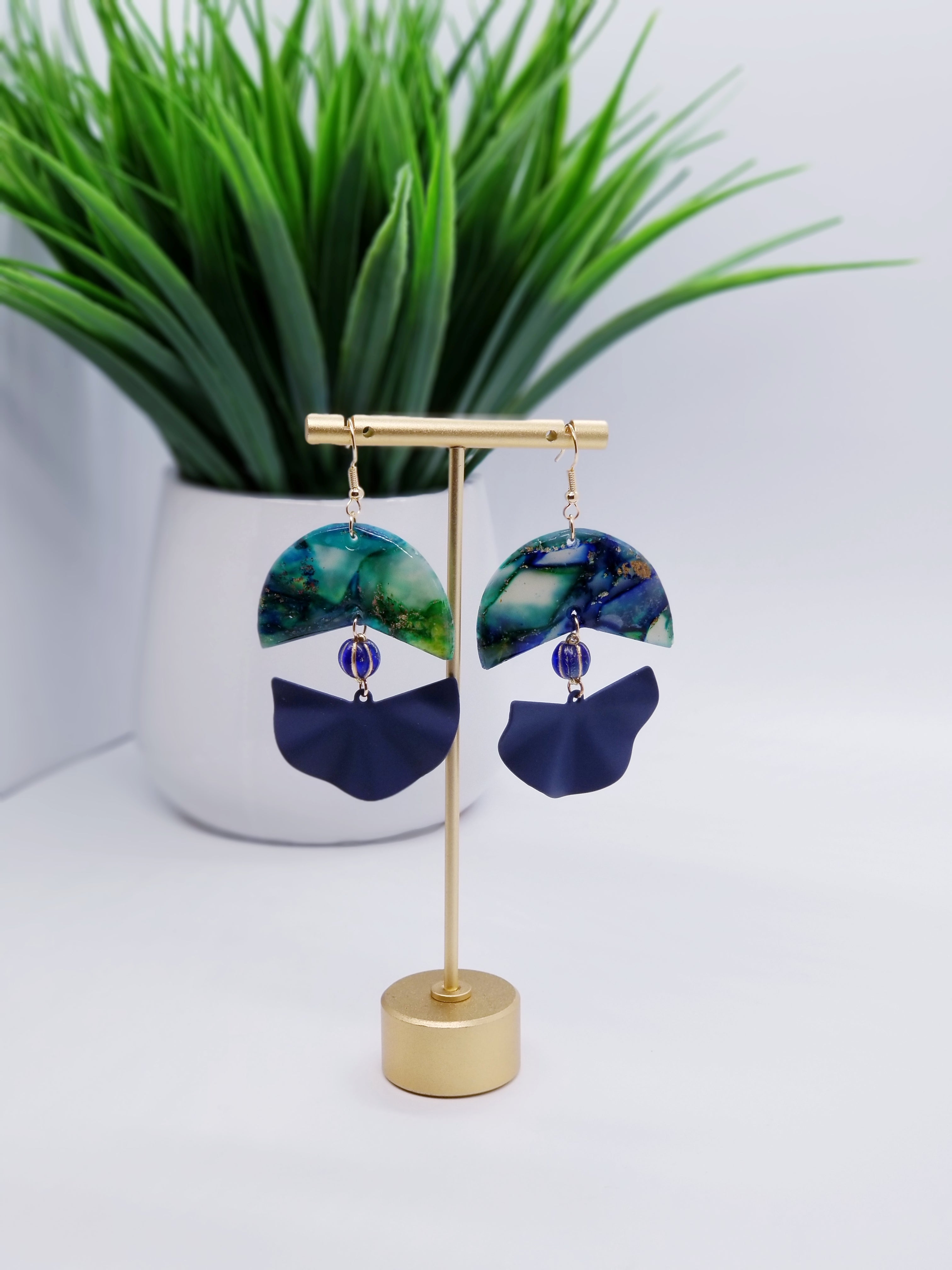 Length: 3 inches | Weight: 0.7 ounces  Designed just for you! The earrings are handmade using green blue and swirl gold resin design, matte blue fanned covered charm, 8mm blue Czech melon beads, and hypoallergenic hooks with back closures. 