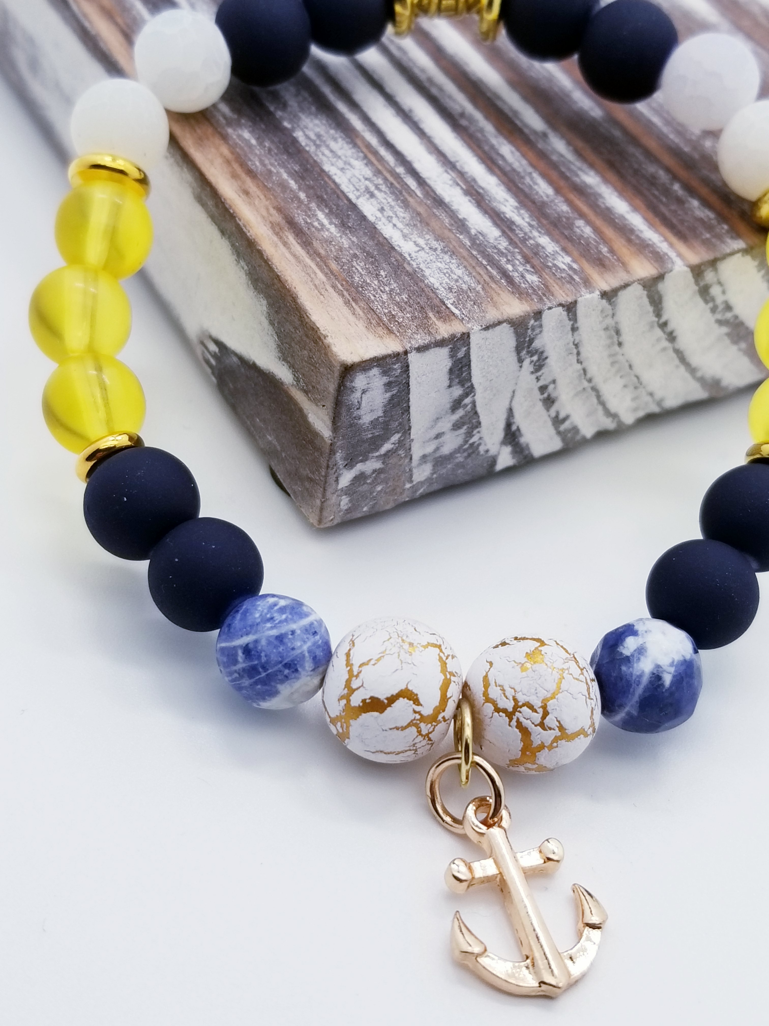 Honor, Courage, and Commitment (US Navy core values) inspired bracelet to honor our troops, veterans, and the families that support them! Anchor charm with white turquoise beads, indigo and navy marbled beads, gold and white marbled beads, navy matte glass beads, yellow glass beads, gold faceted spacer beads, and gold spacers. 