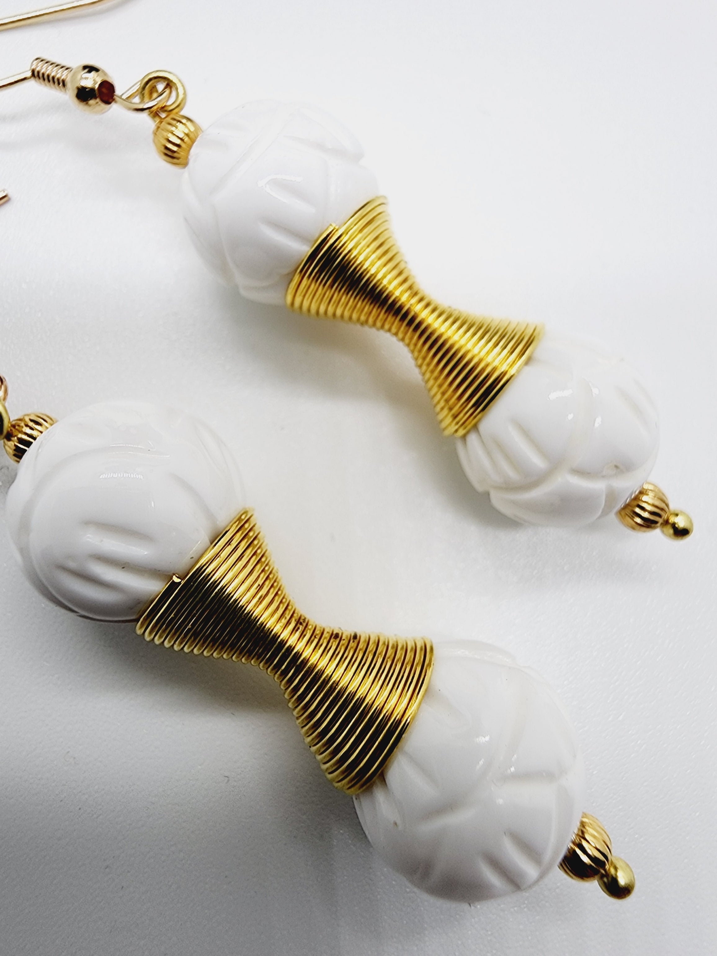 Length: 2 inches | Weight: 0.4 ounces  Distinctly You! These handmade earrings are made using 12mm carved white ceramic beads, gold charm double spring, 2mm gold ribbed seed bead, and hypoallergenic hooks with back closures.  