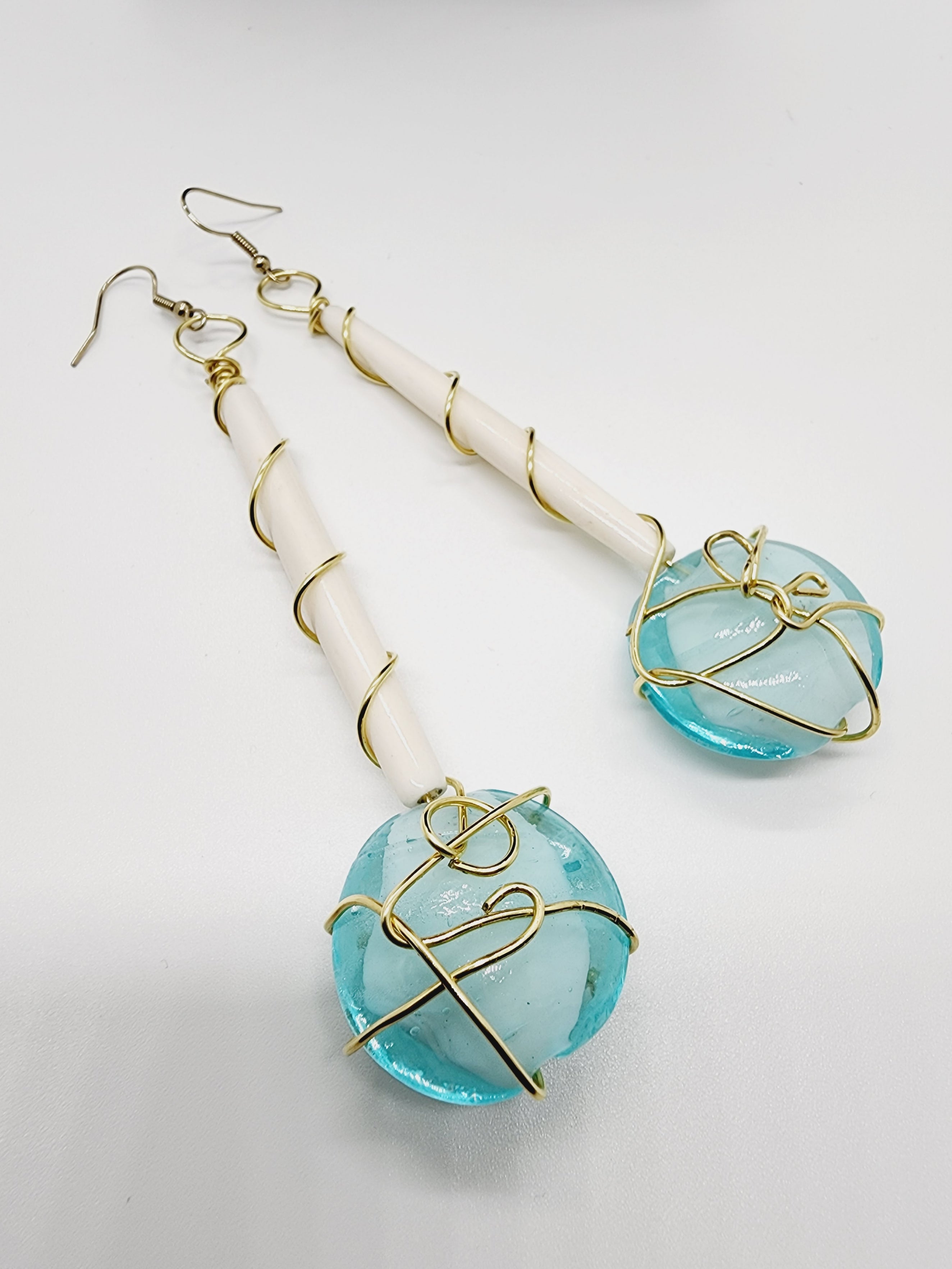 Length: 4.75 inches | Weight: 1.3 ounces  Distinctly You! These handmade earrings are made using white Batik bone tube, gold wire wrapping, Italian Murano aqua glass, and hypoallergenic hooks with back closures. 