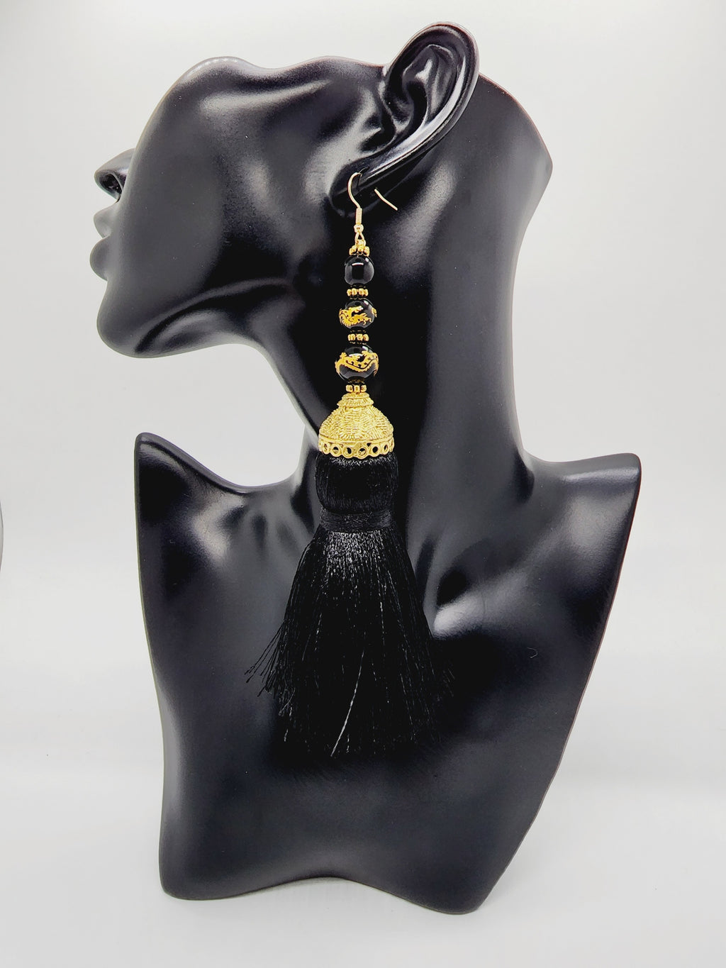 PLEASE BE AWARE: Earrings Hang Past Shoulders  5.5 inches or more  Length: 6 inches | Weight: 2.7 ounces (earlobe supports provided due to weight)  Distinctly You! These handmade earrings are made using gold and filigree beads, gold and black dragon beads, gold dome covers, black silk tassels. and hypoallergenic hooks with back closures. 