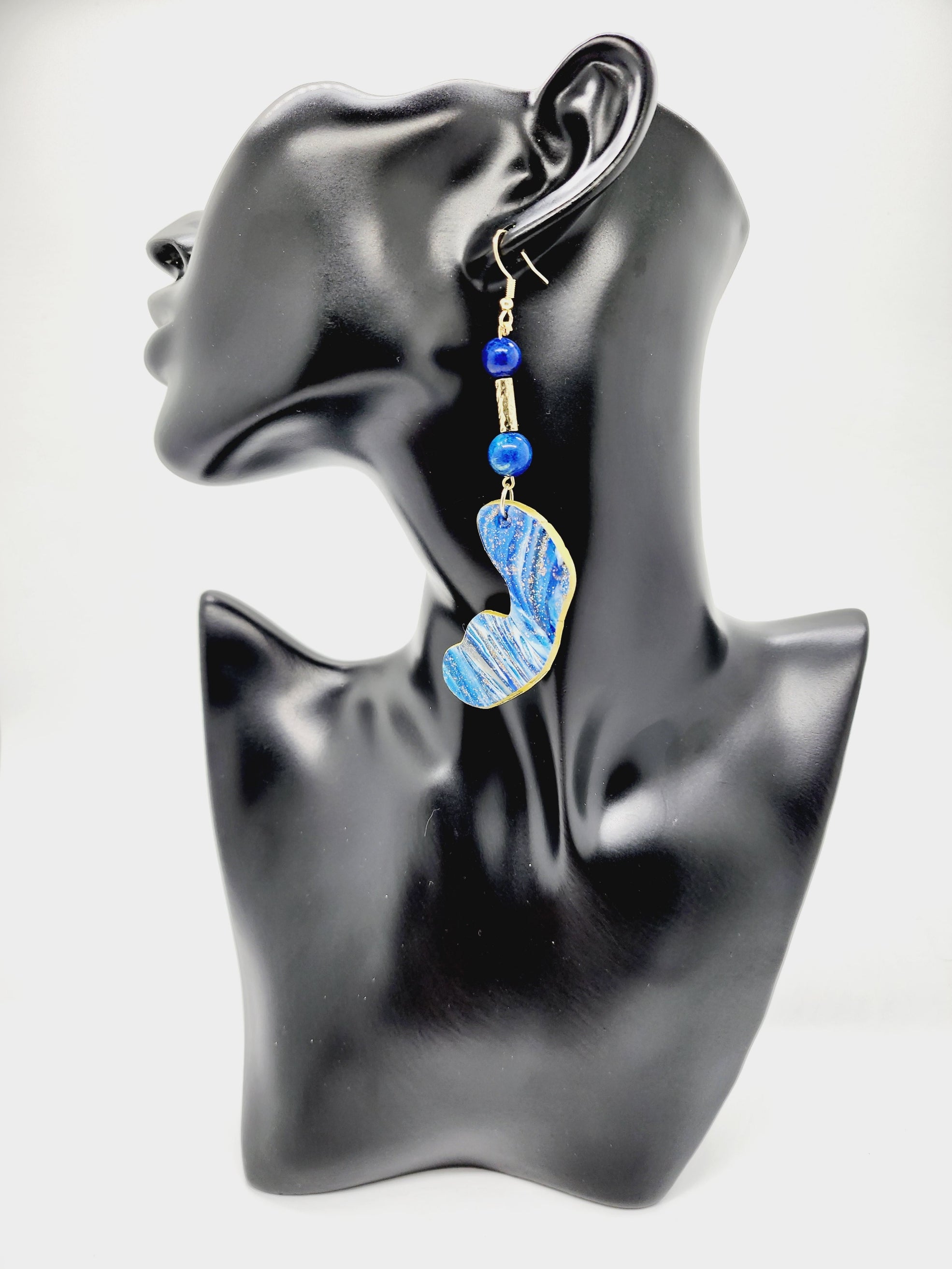Length: 4 inches | Weight: 0.6 ounces   Distinctly You! These handmade earrings are made using blue and gold swirl polymer clay, gold tube bead, blue speckled beads, and hypoallergenic hooks with back closures. 