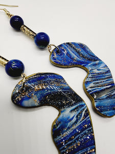 Length: 4 inches | Weight: 0.6 ounces   Distinctly You! These handmade earrings are made using blue and gold swirl polymer clay, gold tube bead, blue speckled beads, and hypoallergenic hooks with back closures. 