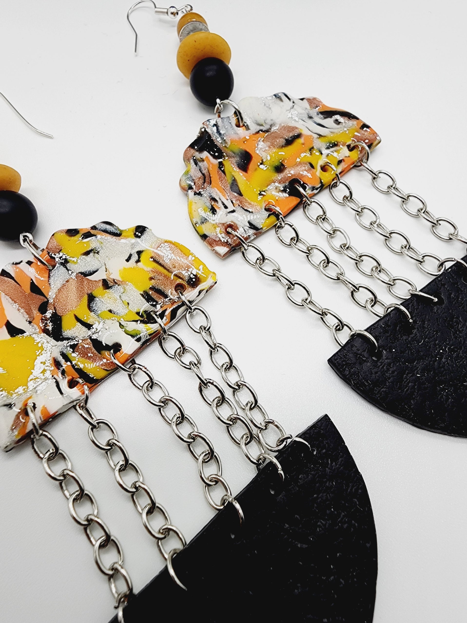 Length: 5.5 inches | Weight: 1.1 ounces   Distinctly You! These handmade earrings are made using orange, yellow, black and grey swirl polymer clay, silver chain, and hypoallergenic hooks with back closures. 