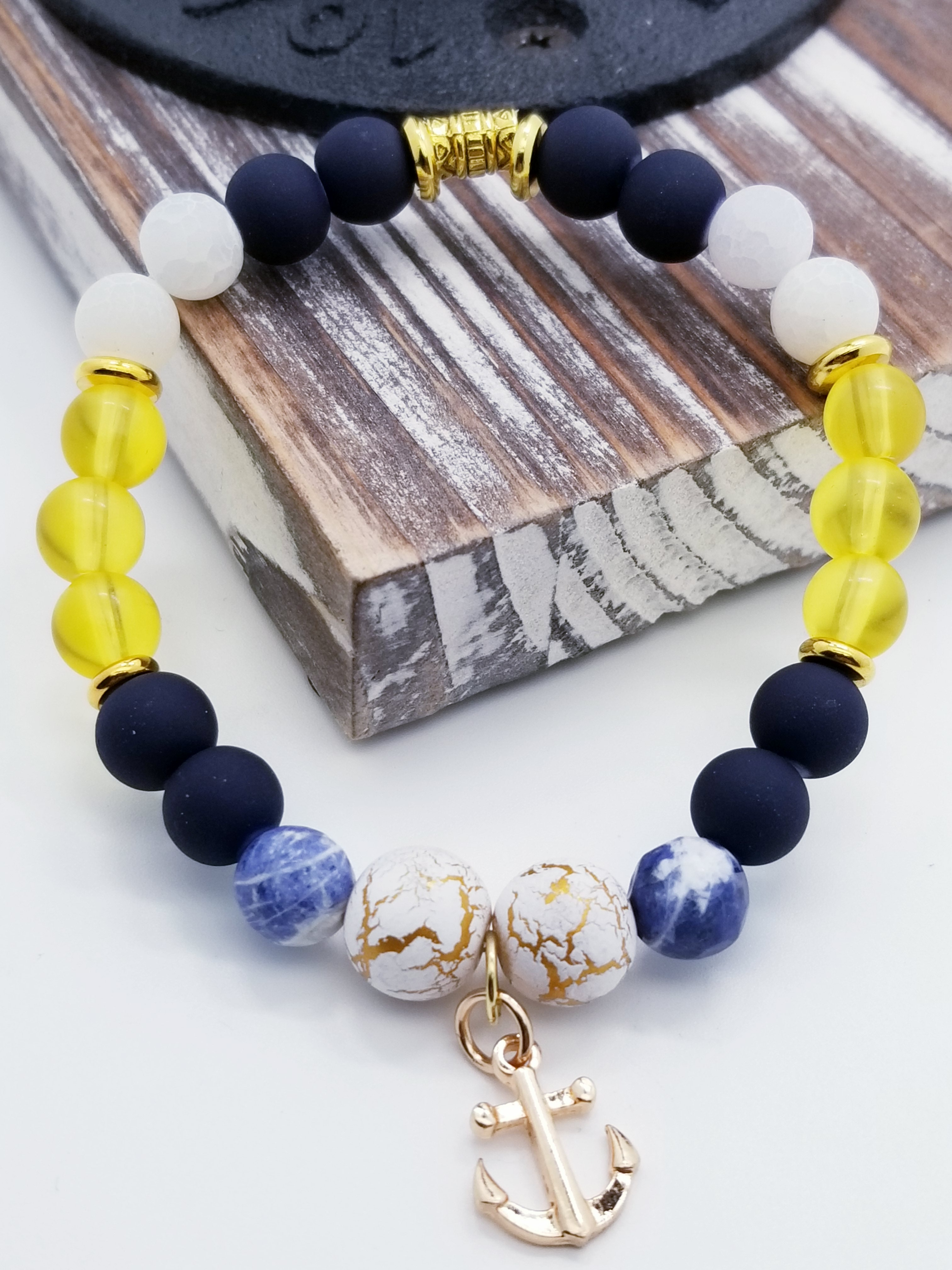 Honor, Courage, and Commitment (US Navy core values) inspired bracelet to honor our troops, veterans, and the families that support them! Anchor charm with white turquoise beads, indigo and navy marbled beads, gold and white marbled beads, navy matte glass beads, yellow glass beads, gold faceted spacer beads, and gold spacers. 