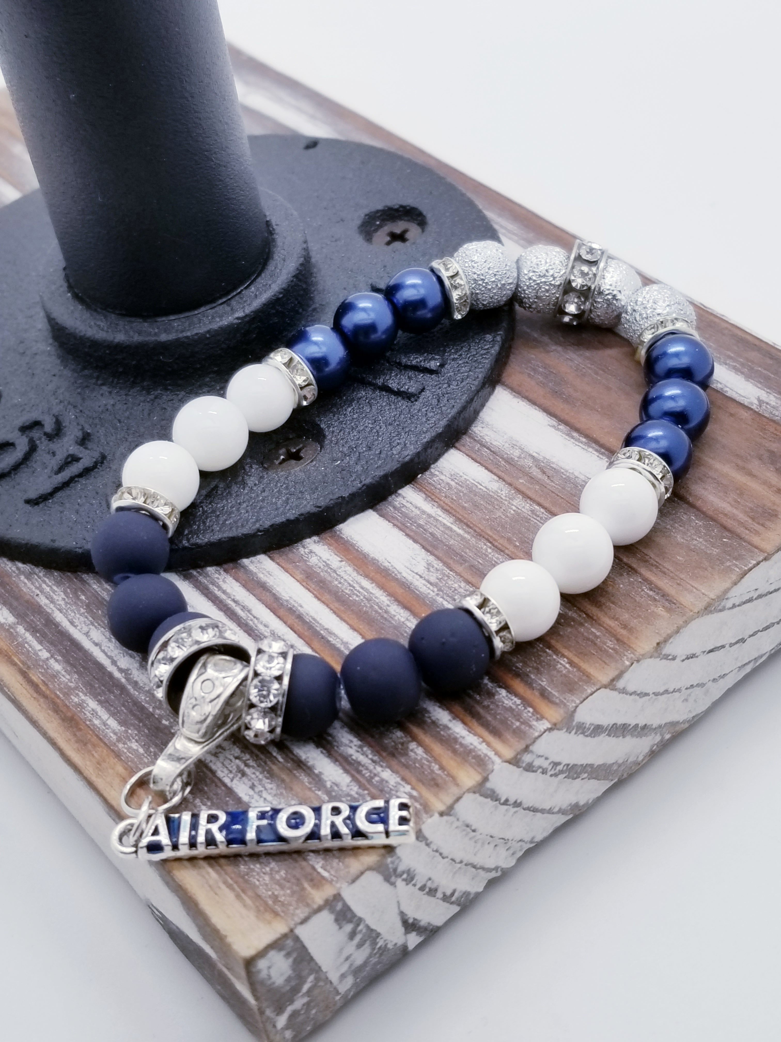 Integrity, Self Service, and Excellence (US Air Force core values) inspired bracelet to honor our troops, veterans, and the families that support them! "Air Force" charm with navy matte glass beads, white turquoise beads, indigo matte metallic beads, silver textured beads, and grade A rondel (silver rhinestone).