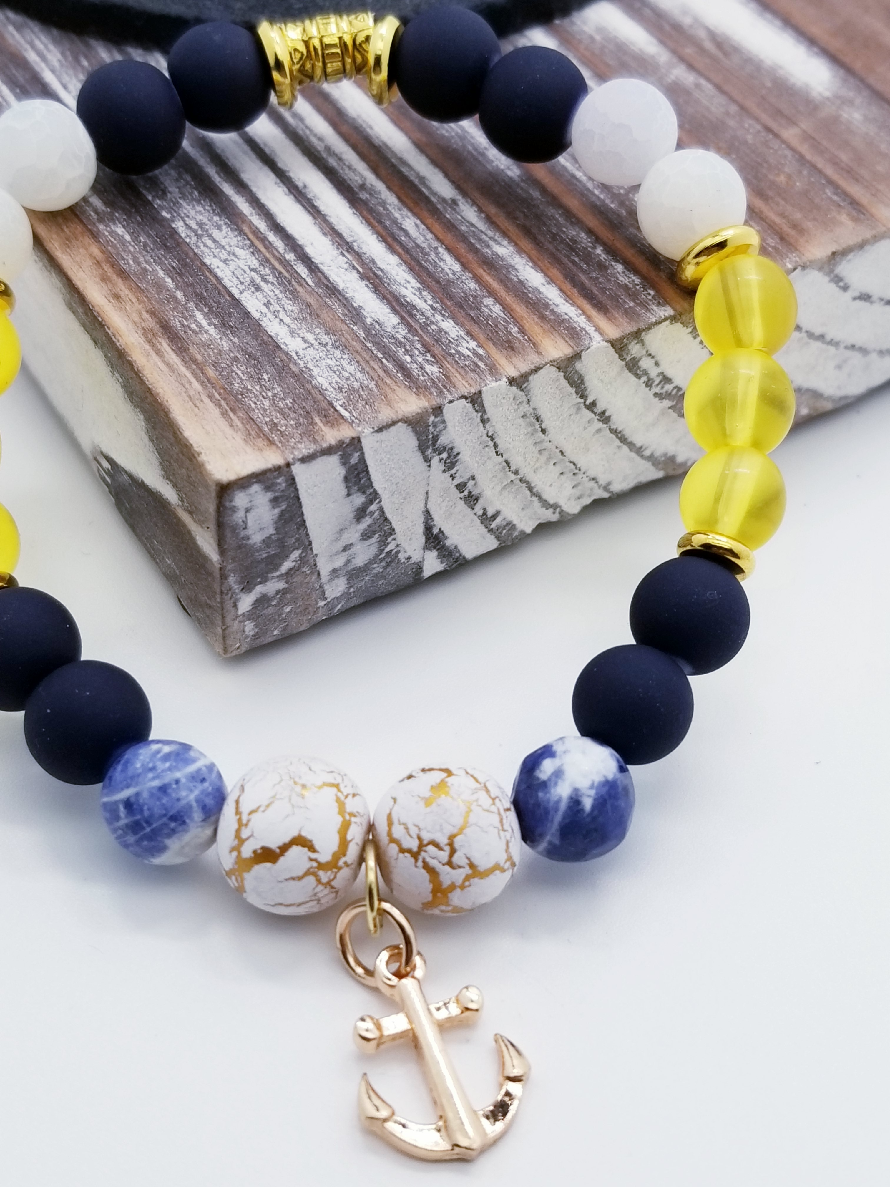 Honor, Courage, and Commitment (US Navy core values) inspired bracelet to honor our troops, veterans, and the families that support them! Anchor charm with white turquoise beads, indigo and navy marbled beads, gold and white marbled beads, navy matte glass beads, yellow glass beads, gold faceted spacer beads, and gold spacers. 